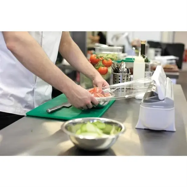 Chef filmant un bac de préparation avec le distributeur de film alimentaire Wrapmaster 4500