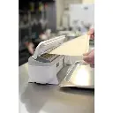 Distributeur de film alimentaire Wrapmaster 4500 : découpe du papier cuisson sur un bac gastro inox