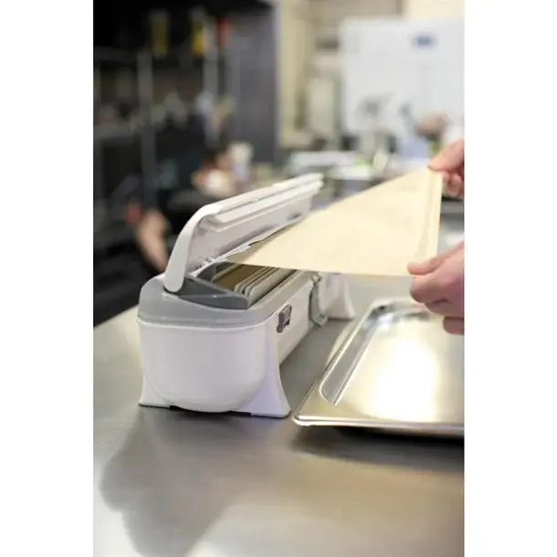 Papier cuisson Wrapmaster 45 cm découpé au distributeur sur un bac gastro inox