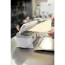 Papier cuisson Wrapmaster 45 cm découpé au distributeur sur un bac gastro inox