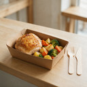 Couteau en bois jetable posé près d'une boîte repas à emporter garnie, sur un comptoir