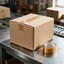 Ruban adhésif d'emballage fermant un carton d'expédition sur un poste de préparation de commandes