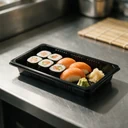 Plateau à sushi 165 × 95 mm en PET noir garni de makis et de nigiris, en cuisine japonaise