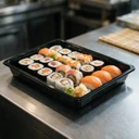 Plateau à sushi 247 × 156 mm en PET noir garni d'un large assortiment à partager, en cuisine japonaise