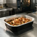 Plat aluminium noir 1 000 ml garni de poulet rôti et légumes en cuisine professionnelle