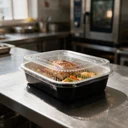 Couvercle transparent clipsé sur un plat aluminium 1 000 ml garni, prêt à emporter